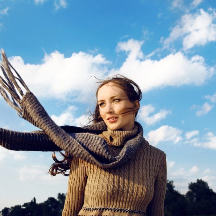 woman with a knitted scarf blowing in the wind