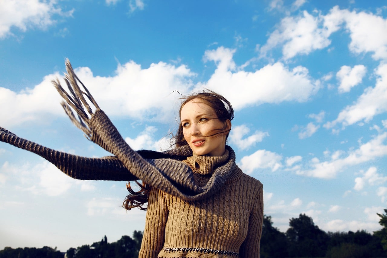 woman with a knitted scarf blowing in the wind