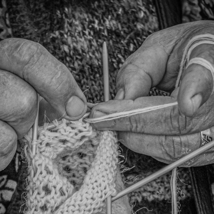 black and white image of woman knitting