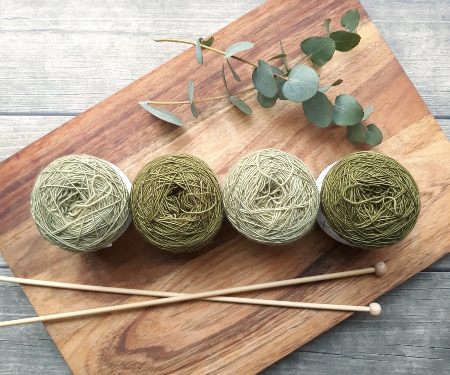 green yarn on board and knitting needles