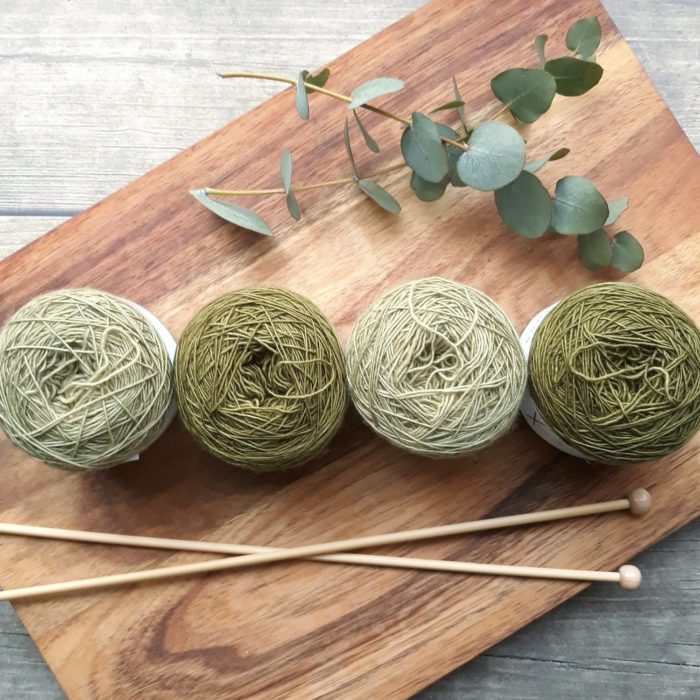 green yarn on board and knitting needles