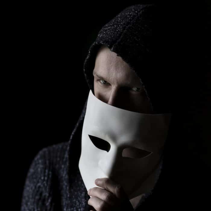 hooded man removing white mask