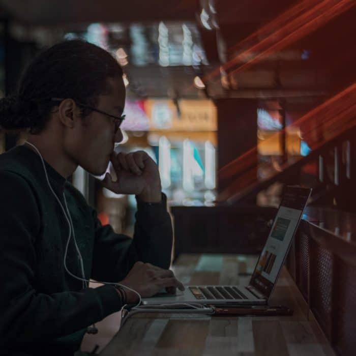 man at desk in a cafe on a laptop