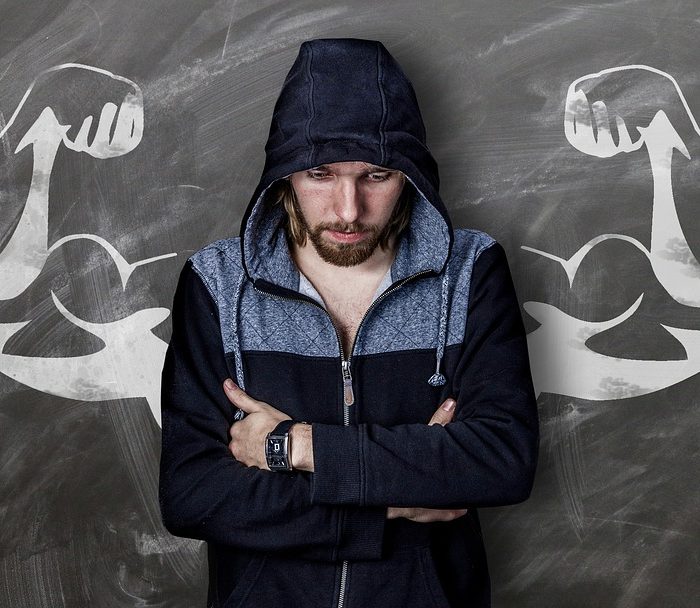 man in hoodie with muscle drawing behind him