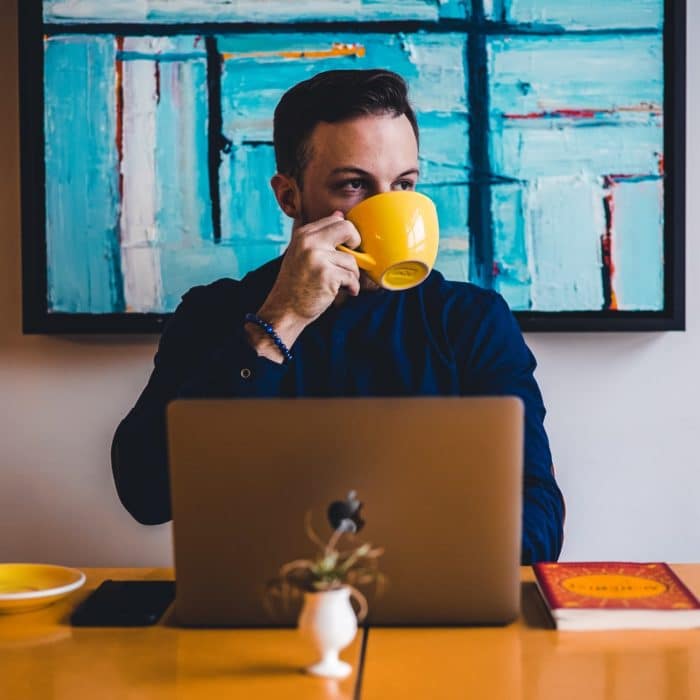 man on laptop sipping tea