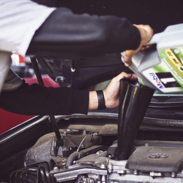 mechanic pouring oil