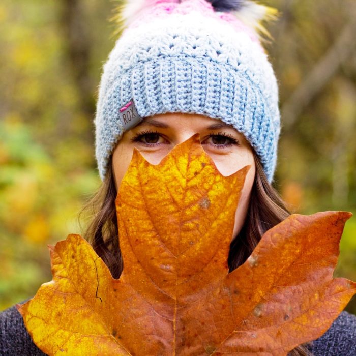 woman hiding behind large leaf