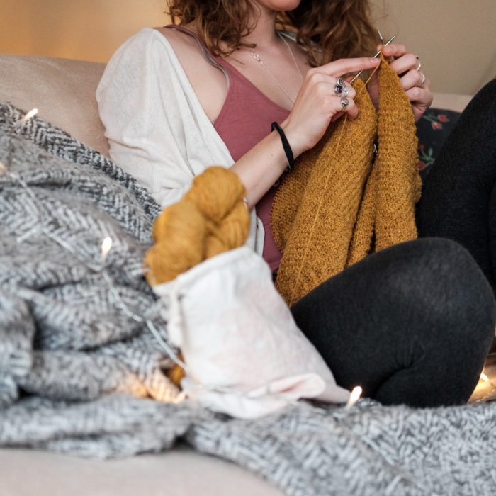 woman knitting on couch