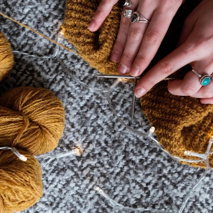 woman knitting on knitted blanket