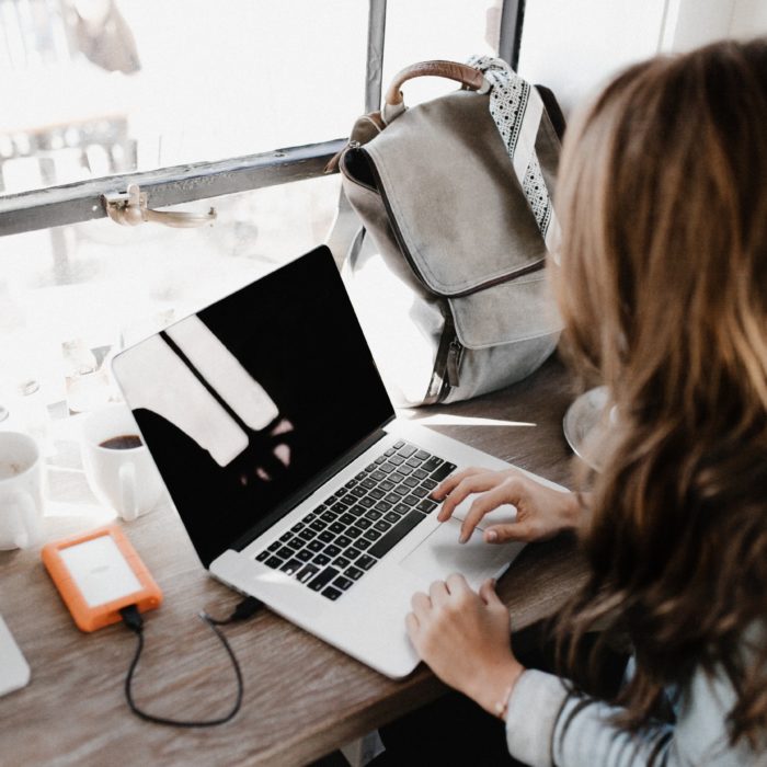 woman on laptop with orange harddrive