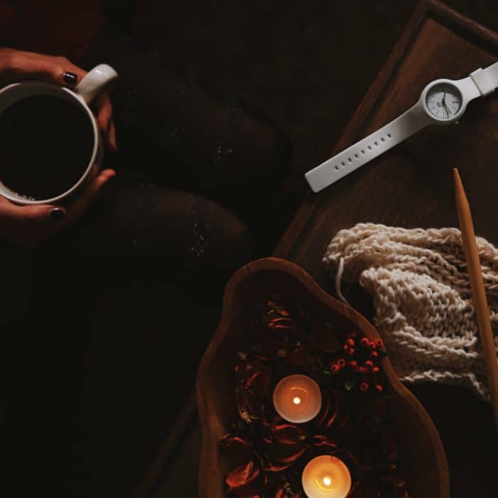 woman sitting at coffee table with knitting