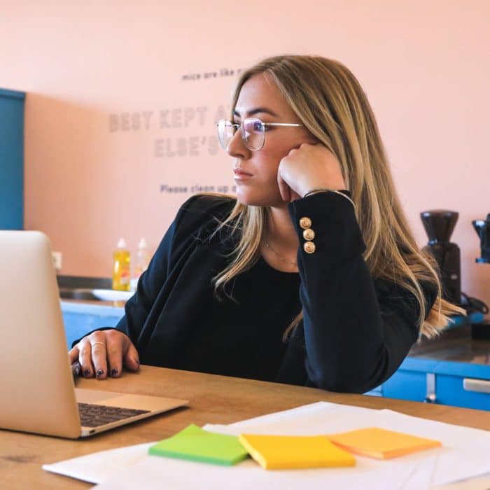 woman sitting at desk with laptop waiting