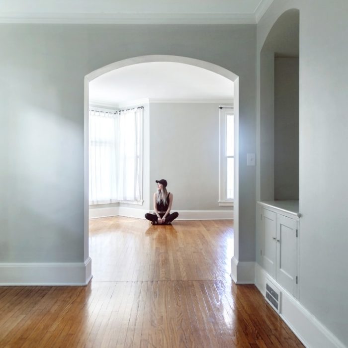 woman sitting on floor in empty house