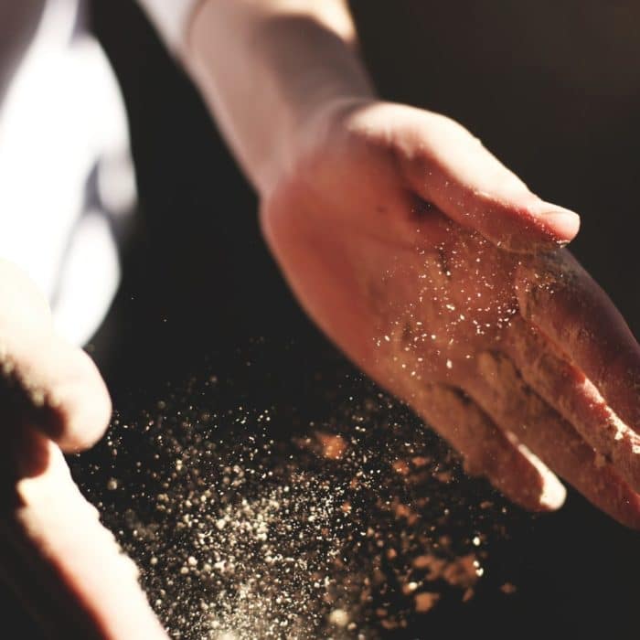 man clapping flour