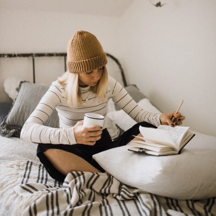 woman on bed writing